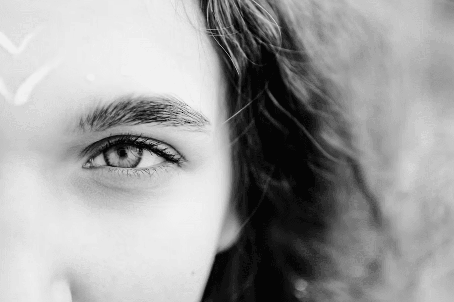 Black-and-white close-up of a softly shaped eyebrow and eye